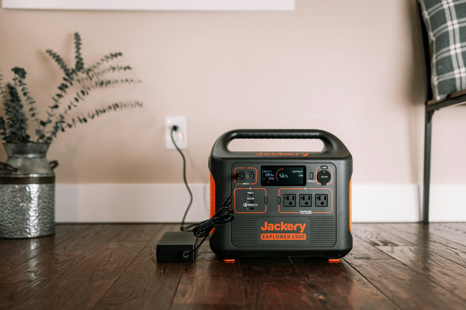 Portable power station plugged in on a wooden floor at home